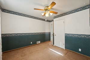 Unfurnished room featuring ceiling fan and carpet