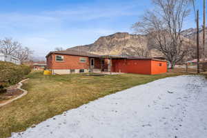 Back of property with a lawn and a mountain view