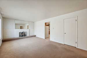 Unfurnished living room featuring light colored carpet