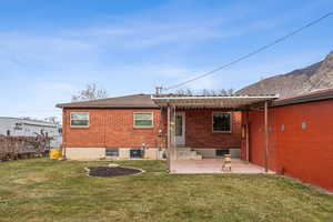 Rear view of house with a mountain view, central AC, a yard, and a patio