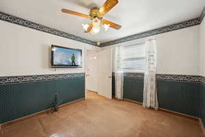 Carpeted empty room with ceiling fan