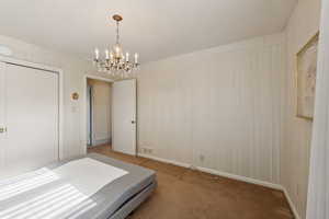 Bedroom with a chandelier and carpet floors