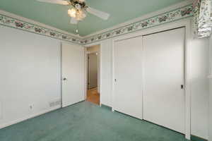 Unfurnished bedroom with carpet flooring, ceiling fan, and ornamental molding