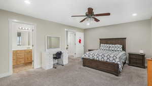 Bedroom featuring ensuite bathroom, ceiling fan, and light carpet