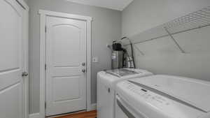 Washroom featuring hardwood / wood-style floors and washer and clothes dryer