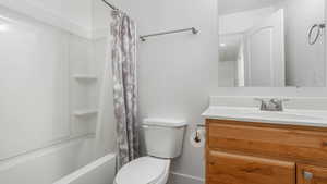 Full bathroom featuring vanity, toilet, and shower / tub combo with curtain