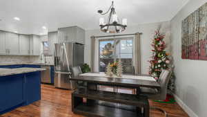 Dining space with light wood-type flooring, an inviting chandelier, and sink