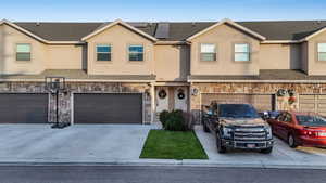 Townhome / multi-family property with solar panels and a garage