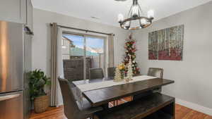 Dining space featuring wood-type flooring and a notable chandelier