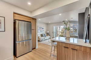 Kitchen featuring stainless steel fridge and light hardwood / wood-style flooring