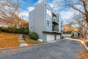 View of property exterior with a garage and a balcony