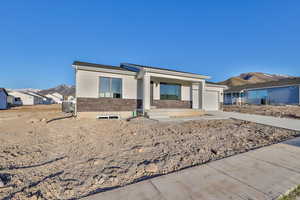 View of front of house with central AC and a garage