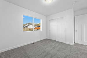 Unfurnished bedroom featuring carpet and a closet