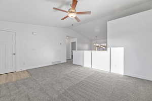 Interior space with ceiling fan with notable chandelier and vaulted ceiling