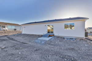 Back house at dusk featuring central air condition unit