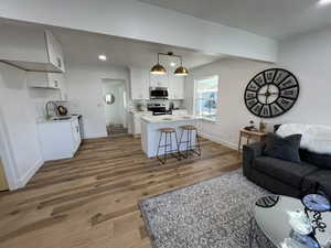 Living room with sink and dark wood-type flooring