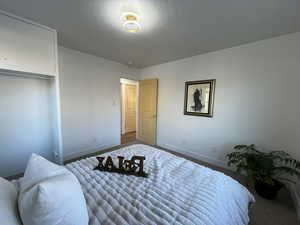 Bedroom featuring a textured ceiling and a closet