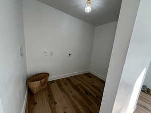 Laundry room featuring hookup for an electric dryer, wood-type flooring, and a textured ceiling