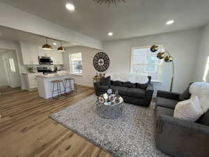 Living room with light hardwood / wood-style floors and a wealth of natural light