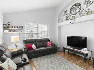 Living room featuring hardwood / wood-style flooring and high vaulted ceiling