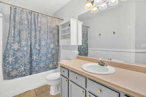 Full bathroom featuring shower / bathtub combination with curtain, tile patterned flooring, vanity, and toilet