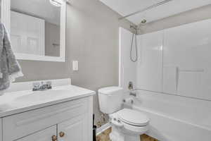 Full bathroom featuring toilet, vanity, and washtub / shower combination