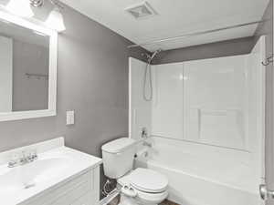 Full bathroom with hardwood / wood-style flooring, vanity, toilet, and shower / bath combination