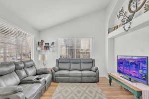 Living room featuring hardwood / wood-style floors and lofted ceiling