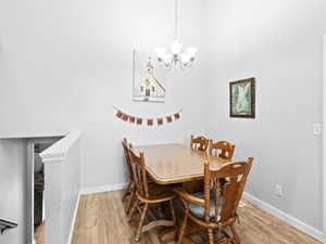 Dining space with hardwood / wood-style floors and an inviting chandelier