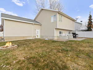 Back of property featuring a patio area, a yard, and an outdoor fire pit