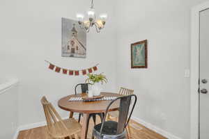 Dining space featuring hardwood / wood-style flooring and an inviting chandelier