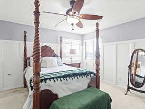 Bedroom with light carpet, a textured ceiling, and ceiling fan