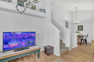 Living room featuring hardwood / wood-style floors, high vaulted ceiling, and a chandelier