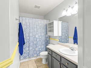 Bathroom with tile patterned floors, vanity, a textured ceiling, and toilet