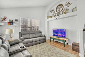 Living room featuring lofted ceiling and wood-type flooring