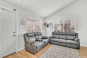 Living room featuring plenty of natural light, vaulted ceiling, and light wood-type flooring