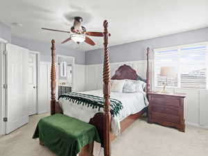 Carpeted bedroom with ceiling fan, a textured ceiling, and connected bathroom