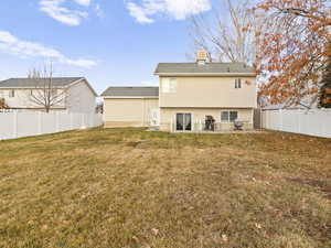 Back of house with a lawn and a patio area