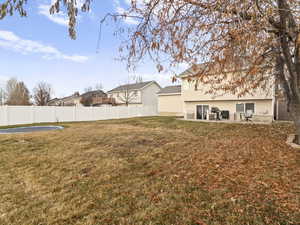 View of yard with a trampoline and a patio area