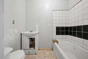 Bathroom with tile patterned floors, sink, toilet, and a bath