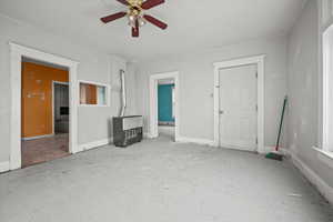 Unfurnished living room featuring ceiling fan