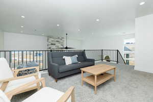 Living room featuring ceiling fan and light colored carpet