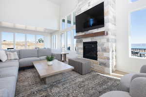 Living room with a fireplace, a towering ceiling, and wood-type flooring