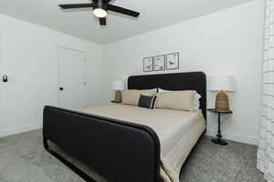 Carpeted bedroom featuring ceiling fan