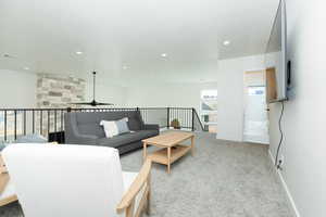 Carpeted living room featuring ceiling fan