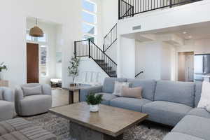 Living room with a towering ceiling and hardwood / wood-style flooring