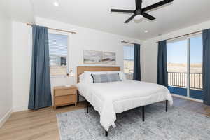 Bedroom with ceiling fan, light hardwood / wood-style flooring, and multiple windows