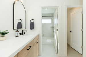 Bathroom featuring tile patterned flooring, vanity, and tiled shower / bath