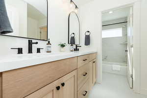 Bathroom featuring tile patterned floors, vanity, and tiled shower / bath combo