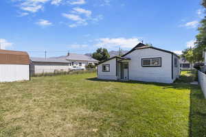 Rear view of property with a yard